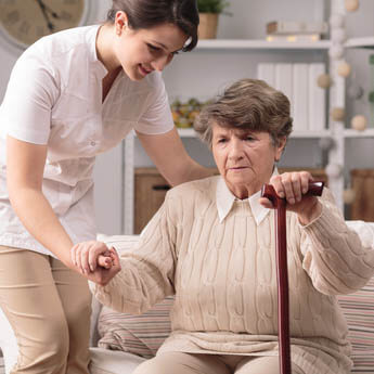 Old lady receiving assistance standing up with walking stick